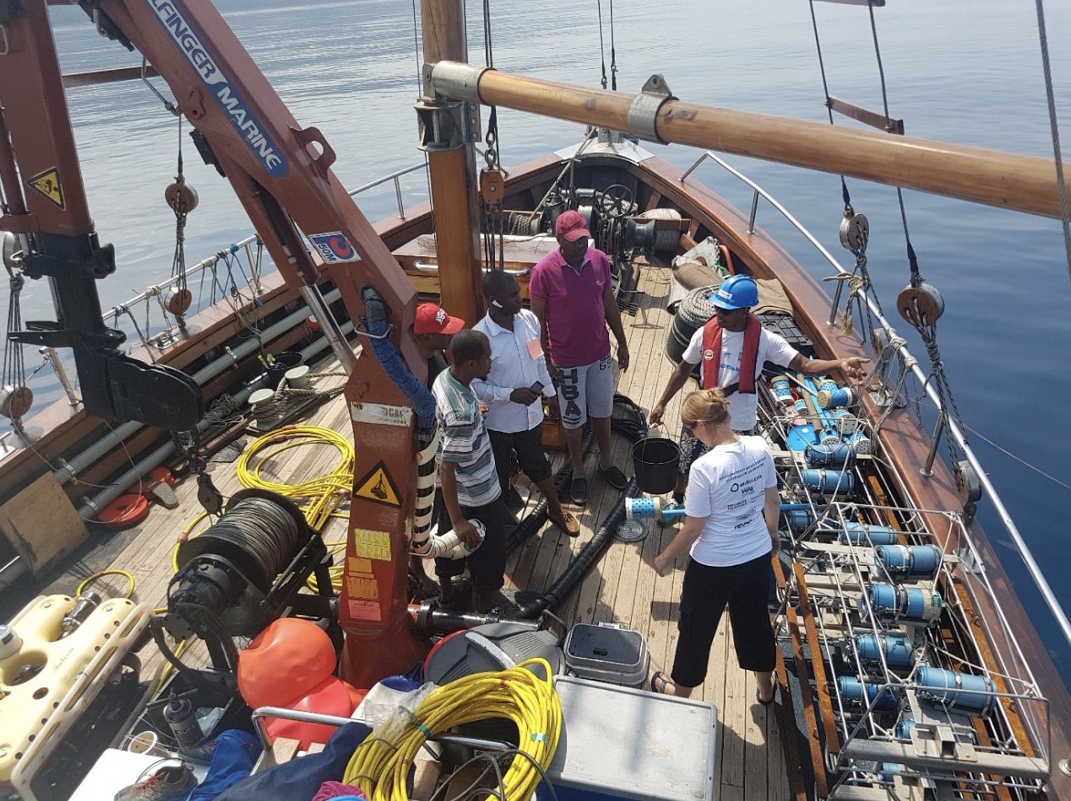 Credit- WildOceans: Lucy and Youssouf (right) showing fishers (left) the bait camera systems aboard R/V Angra Pequena Credit- WildOceans: Lucy and Youssouf (right) showing fishers (left) the bait camera systems aboard R/V Angra Pequena